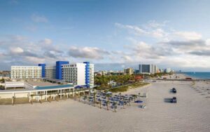 aerial view down beach with hotel and rows of loungers at hilton clearwater beach resort