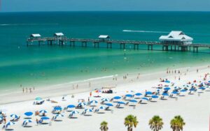 aerial view of beach and pier with rows of umbrellas at clearwater beach