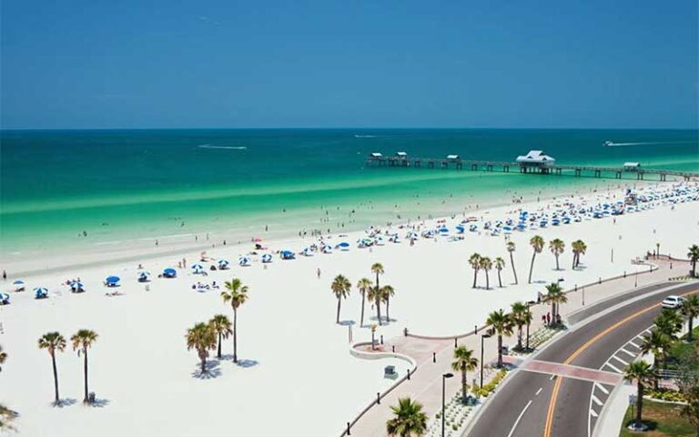 aerial view of beach with pier and curving highway at clearwater beach