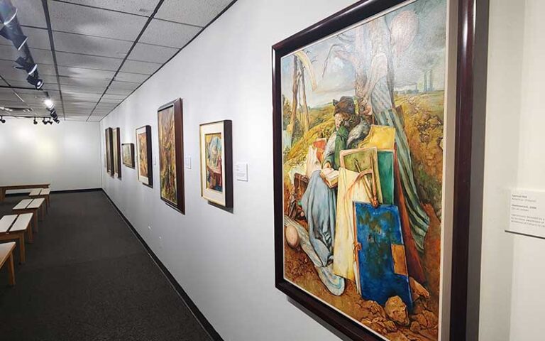 art hung on exhibit wall with benches at the florida holocaust museum st pete