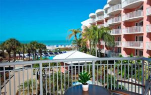 balcony view over pool and beach with pink building along right at beach house suites st pete