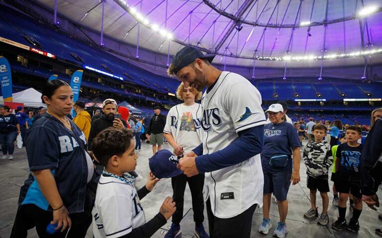 boy getting autographed hat from baseball player in stadium at tropicana field st pete