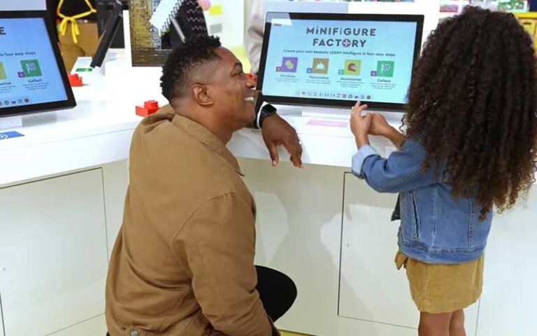 dad and daughter at minifigure kiosk at the lego store at disney springs orlando