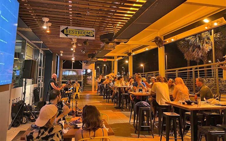 dining patio at night with live musician at badfins food drink clearwater beach