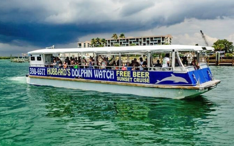 dolphin tour boat on inlet with green water at johns pass village boardwalk madeira beach
