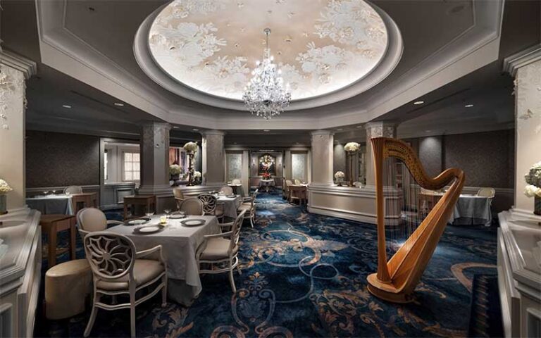 elegant dining room with tables harp and chandelier at victoria alberts at grand floridian walt disney world resort orlando