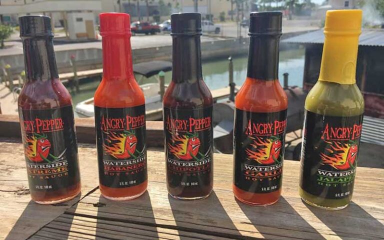 five different hot sauce bottles on marina deck at angry pepper madeira beach st pete