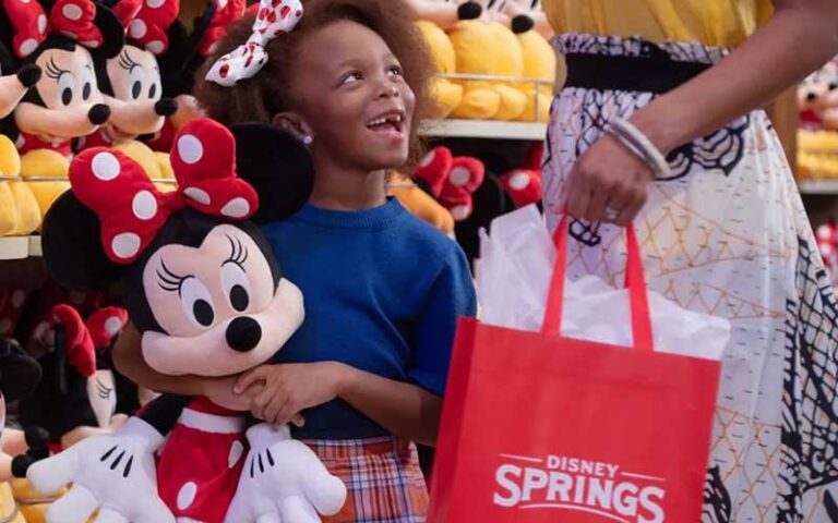 girl with minnie plush toy and mom at world of disney store disney springs orlando
