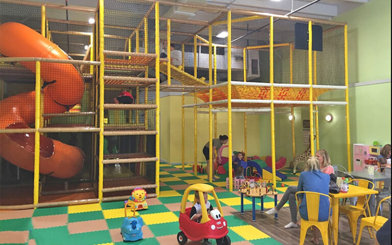 indoor playground structure with slide and seating area with parents at ready set play st augustine