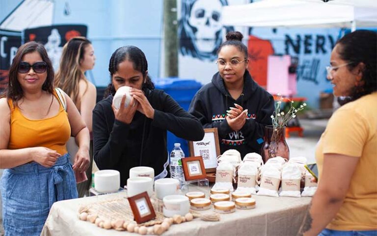 ladies smelling candles at booth at st pete indie flea