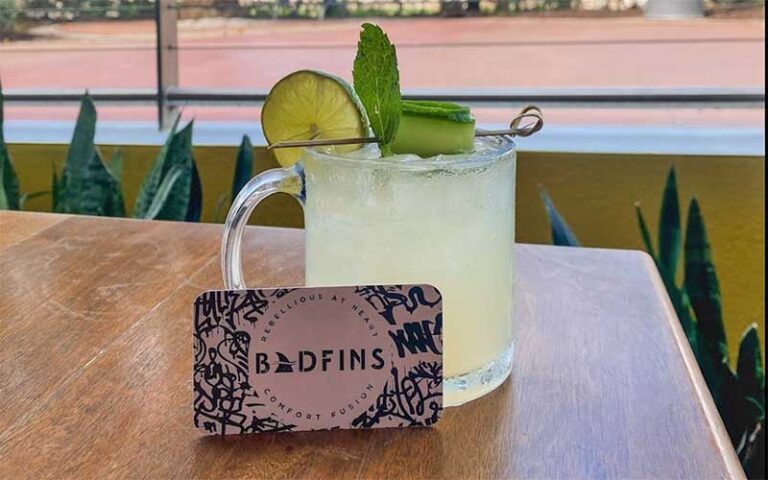 mojito in rocks glass with logo card on outdoor patio table at badfins food drink clearwater beach