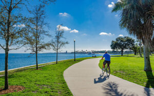 park along water with trees and bicycler on curving sidewalk at vinoy park st pete