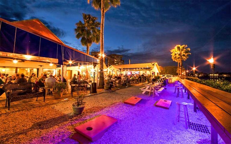 patio dining at night with palms and string lighting at seabreeze island grill st pete clearwater