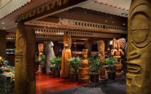 restaurant interior with fountains and wooden tiki sculptures at ohana at polynesian village resort walt disney world orlando