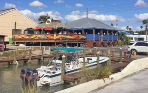 restaurant on dock with boat and surfboard adorned patio at angry pepper madeira beach st pete