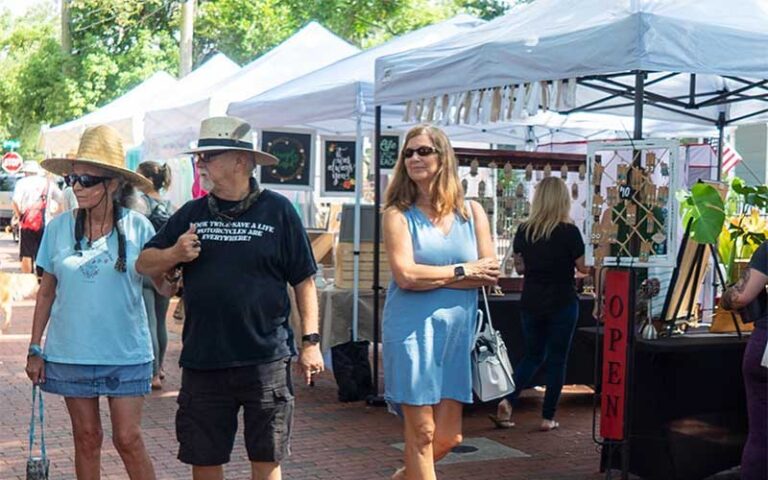 shoppers walking by stalls in sunlight at safety harbors market on main clearwater