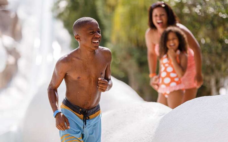 smiling boy getting off end of slide on summit plummet at blizzard beach water park walt disney world resort orlando