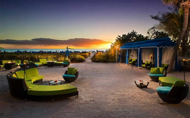 sunset over beach lounge seating with cabanas at rumfish beach resort st pete