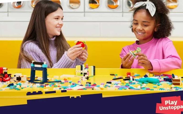 two girls playing at lego table at the lego store at disney springs orlando