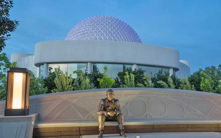 walt dreamer statue seated on bench with spaceship earth in background at epcot walt disney world resort orlando
