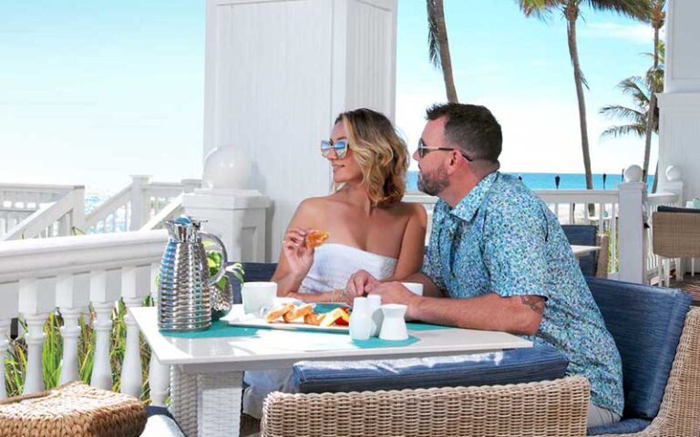 couple having breakfast on veranda overlooking ocean at pelican grand beach resort fort lauderdale