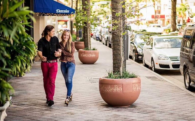 couple walking along shopping district street at las olas boulevard fort lauderdale