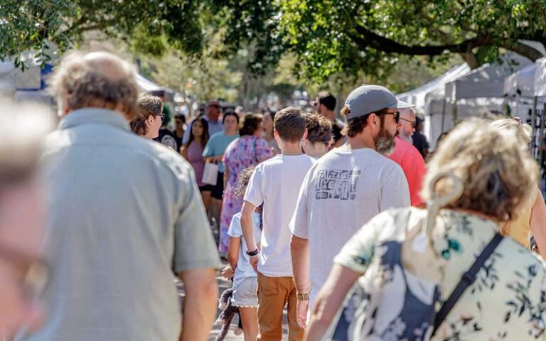 crowd of shoppers at market under trees at palafox market pensacola