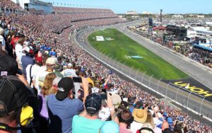 crowded stands at race track with cars racing by at daytona international speedway daytona beach