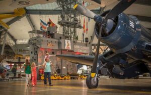family walking around large airplane with boy touching wing at national naval aviation museum pensacola