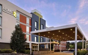 front exterior twilight view of hotel and entrance at home2 suites by hilton orlando international drive south