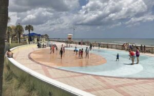 oval splash pad with kids and beach in background at sun splash park daytona beach