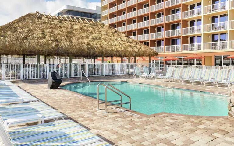 pool deck with hotel and tiki bar at hampton inn daytona beach beachfront
