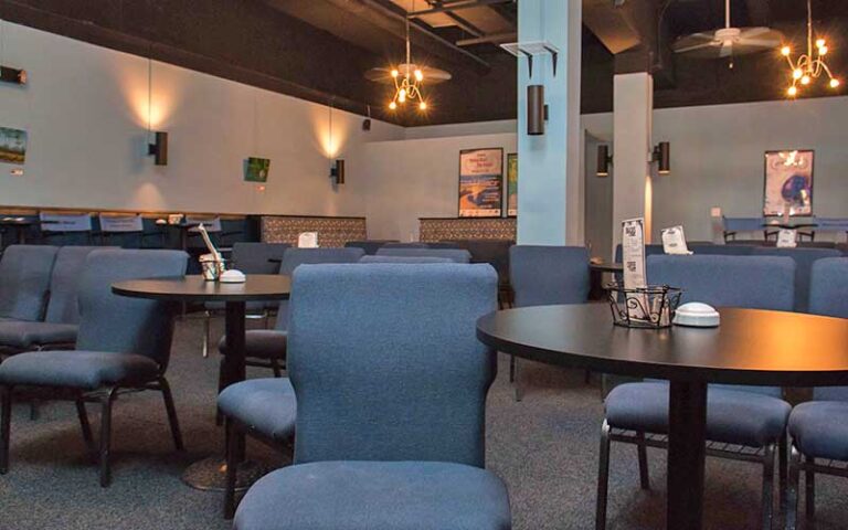 theater room with comfortable seating dining chairs and tables at cinematique theater daytona beach