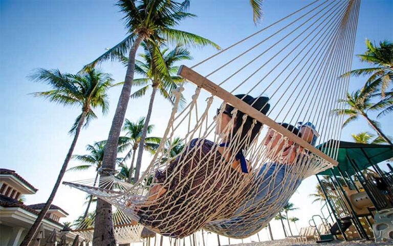 view from below of couple in hammock on beach at lago mar beach resort club fort lauderdale