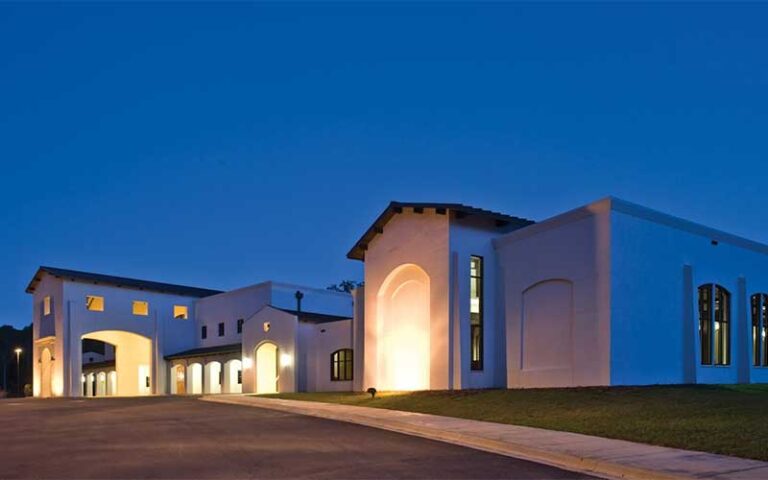 exterior of lighted spanish style building at night at mission san luis tallahassee
