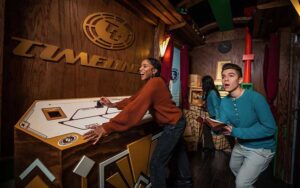 young lady with friends controlling time machine at the escape game