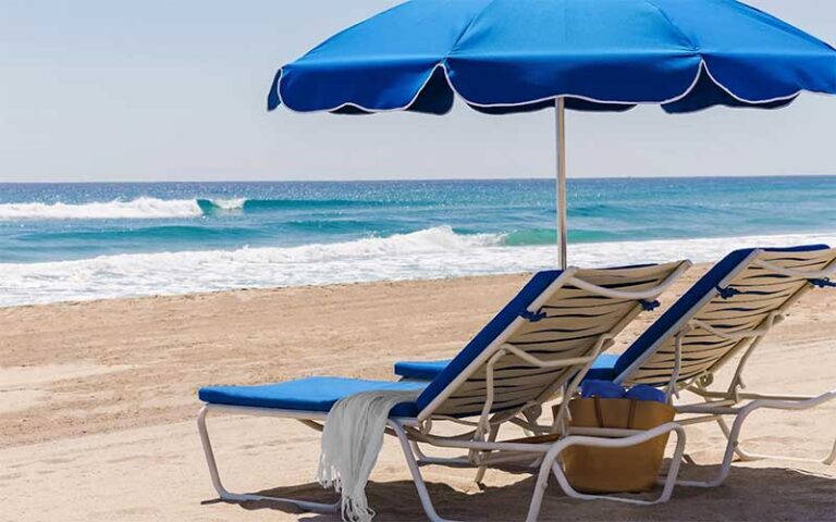 two lounger chairs and umbrella on beach at the seagate beach club delray beach