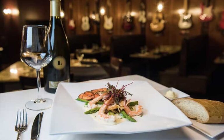dining table setting with shrimp entree and wine at firefly panama city beach