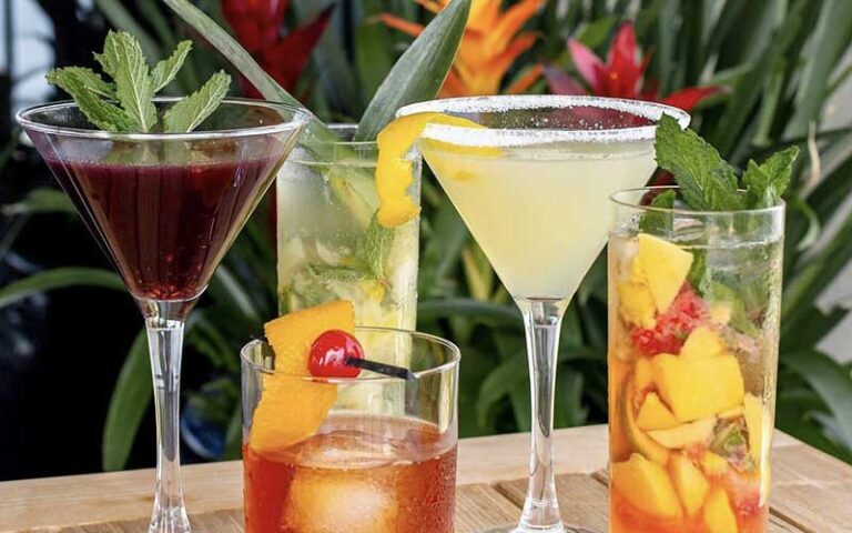 four different tropical cocktails on patio table at the grand marlin panama city beach