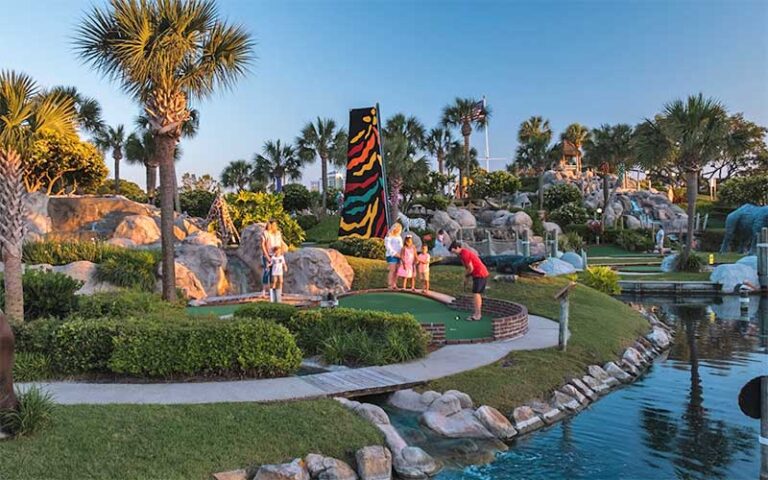 putters in mini golf course at twilight at coconut creek family fun park panama city beach