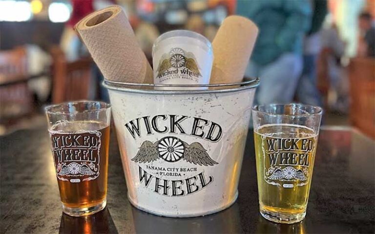 tabletop in dining area with beer and branded bucket at the wicked wheel panama city beach