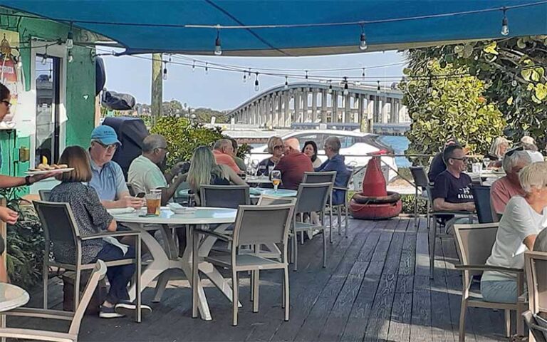 diners on covered patio with causeway bridge in background at 12a buoy fort pierce