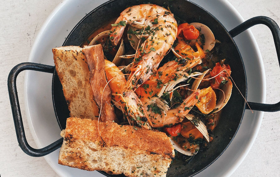 savory crawfish entree with garlic toast in black skillet at sandbar seafood spirits anna maria