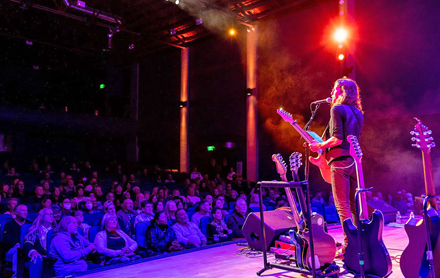 singer with guitar performing on stage with crowd at reilly arts center ocala
