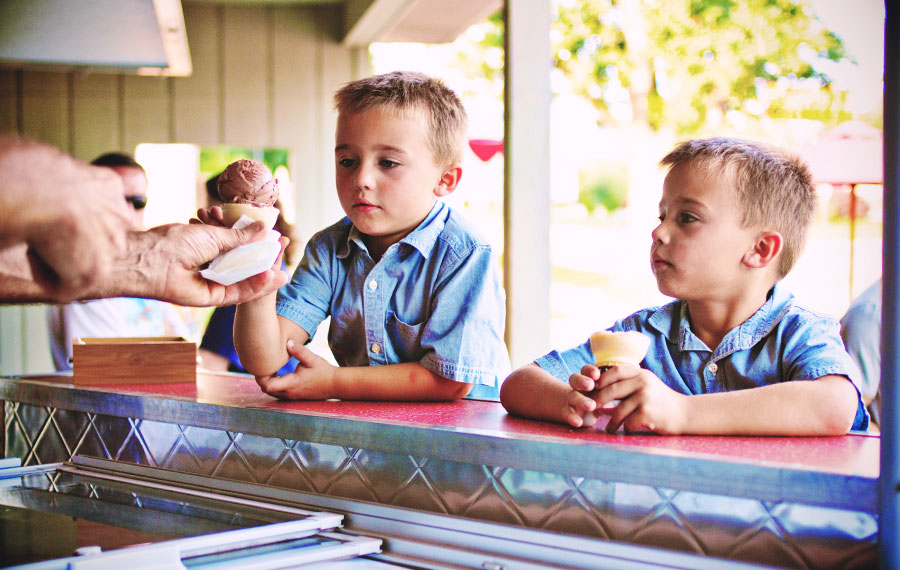 young boys getting ice cream from cones vendor in outdoor patio area