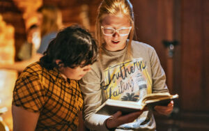 young ladies looking through book at amelia island escape rooms