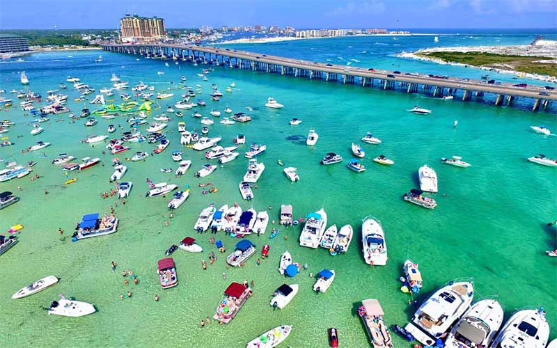 aerial view of sand bar with boats near bridge and harbor at crab island destin