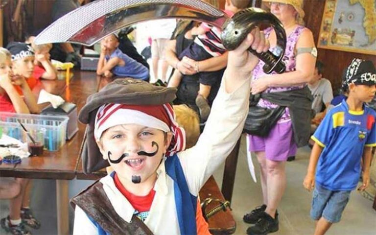 boy dressed as pirate raising sword at buccaneer pirate cruise destin