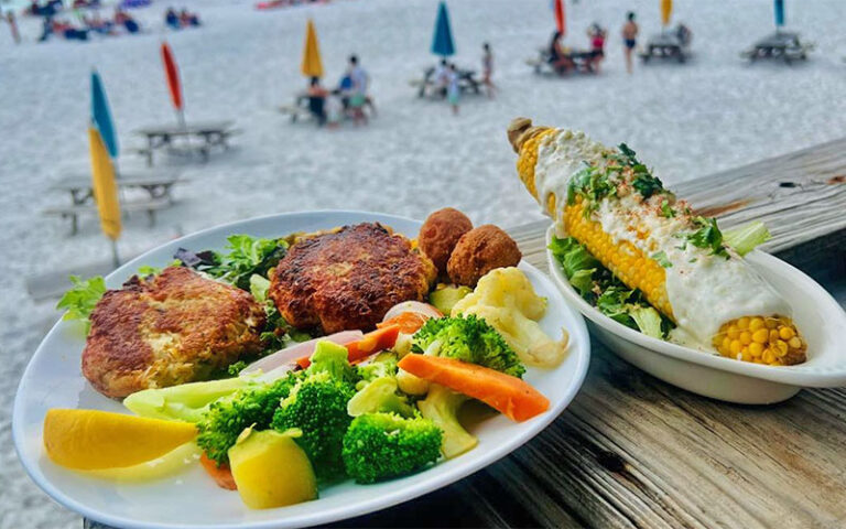 crab cakes with cob corn on deck over beach at pompano joes destin