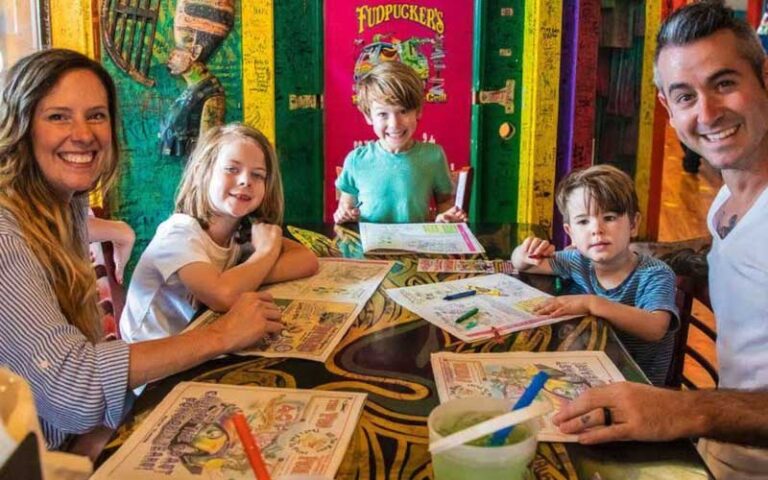 family seated at dining table with menus at fudpuckers beachside bar grill destin